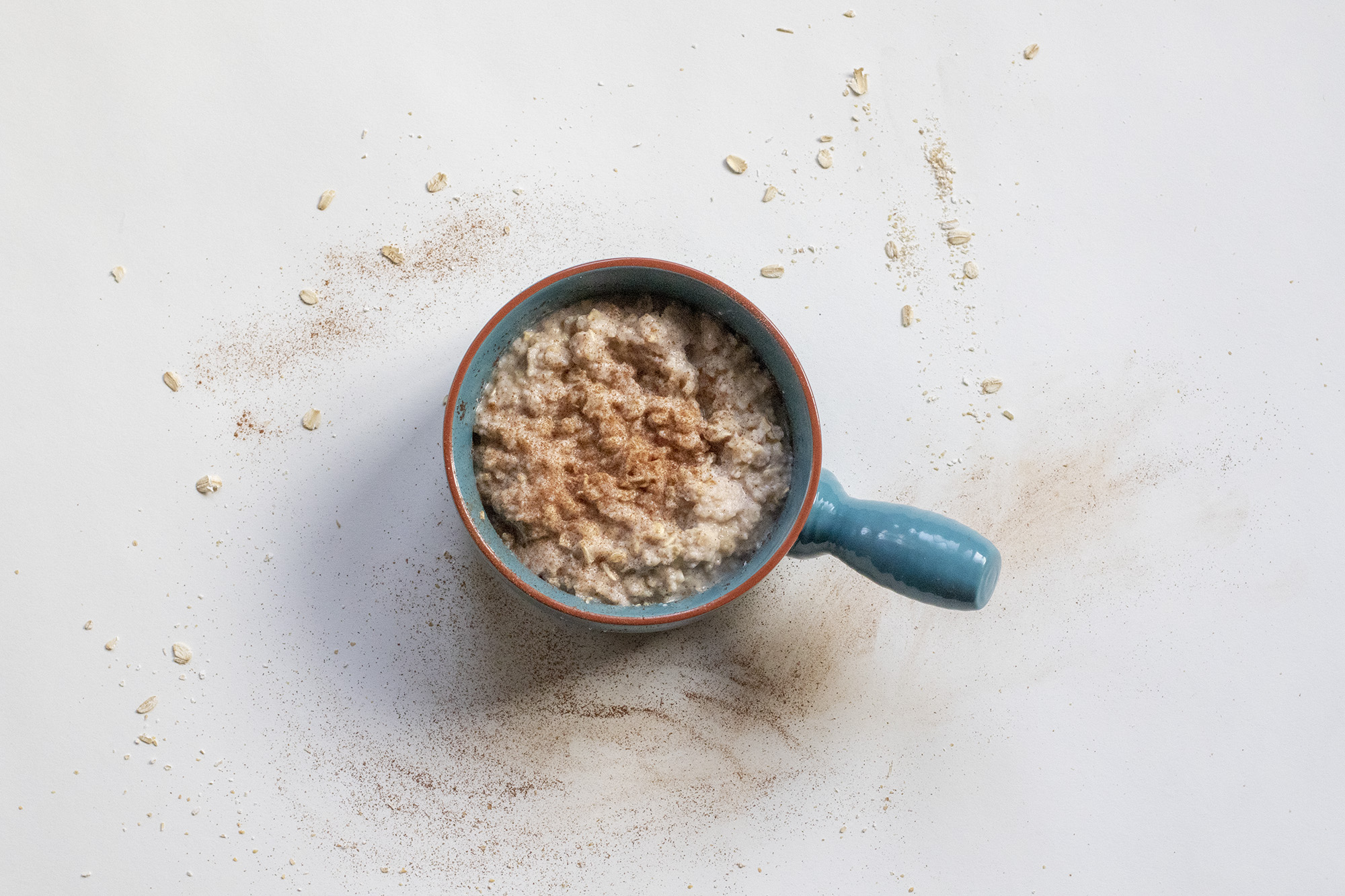 Banana egg white oatmeal in a blue bowl on a white background.